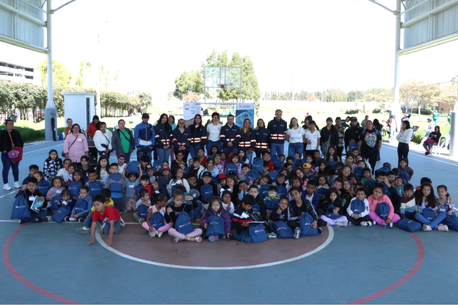 Niños con kits escolares junto al Gerente de la EFR