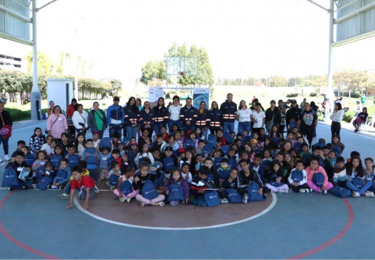 Niños con kits escolares junto al Gerente de la EFR