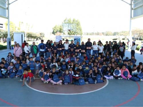 Niños con kits escolares junto al Gerente de la EFR